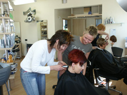 Friseurmeisterin Kirsten Bosecke (Mitte) und eine ihrer zwei Auszubildenden: „Für mich ist es wichtig, dass jeder aus unserem Team gerne zur Arbeit kommt. Das spüren und schätzen auch die Kunden.“