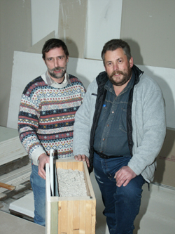 Claus Wust (l.) und Lothar Lück erläutern das Prinzip der ökologischen Wärmedämmung: Auf die eigentliche Außenwand folgt die Zellulosedämmung, eine Dampfbremspappe, die Installationsebene und schließlich innen der Gipskarton.