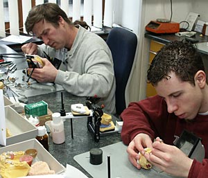 Foto: Zahntechnikermeister Detlef Röhrig (hinten) bildet mit Martin Enderle seinen ersten Lehrling aus.
